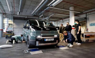 People examining a car in an indoor garage or showroom.