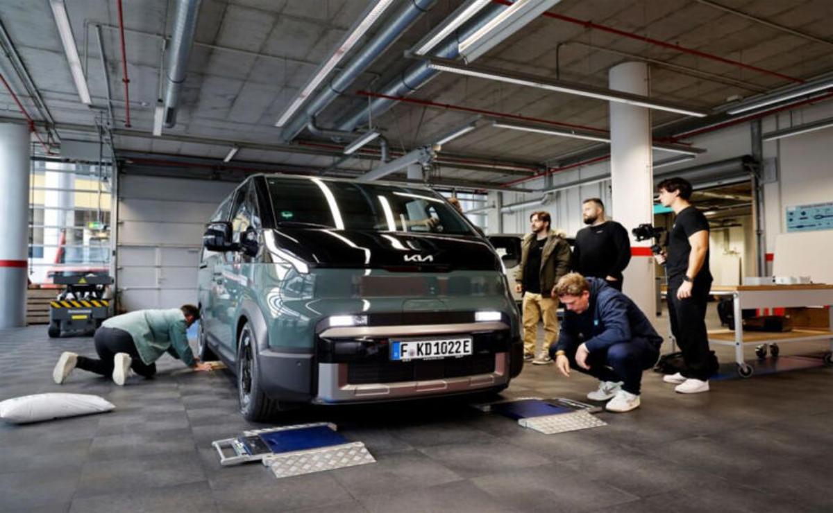 People examining a car in an indoor garage or showroom.