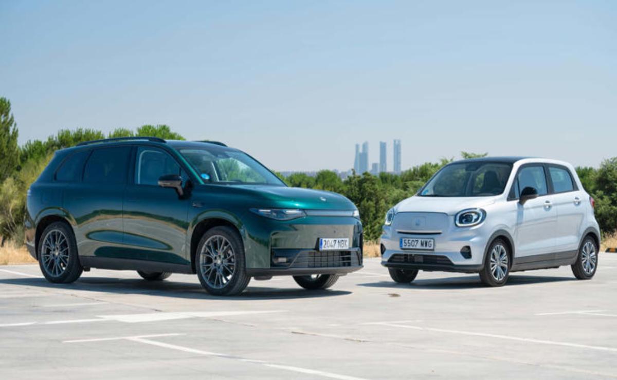 Two modern electric SUVs parked side by side on a rooftop.