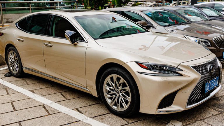 A white luxury sedan parked in a parking lot.