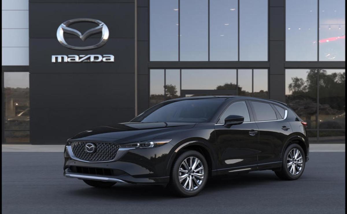 Sleek black Mazda SUV parked outside a showroom at dusk.