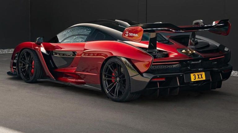 Sleek red and black McLaren sports car with aerodynamic design and rear spoiler.