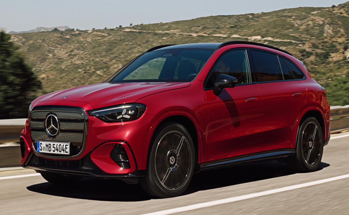 A sleek red luxury SUV driving on a scenic road.