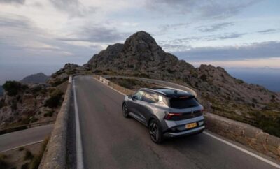 SUV driving on a winding mountain road during dusk.