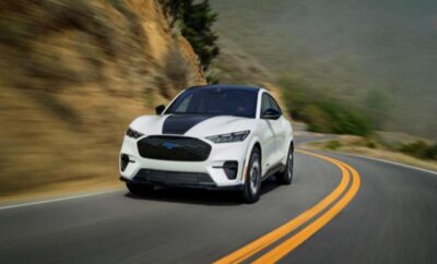 White sports SUV driving on a winding mountain road.