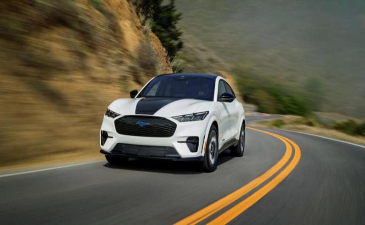 White sports SUV driving on a winding mountain road.