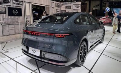 Sleek gray electric sedan displayed at an auto show.
