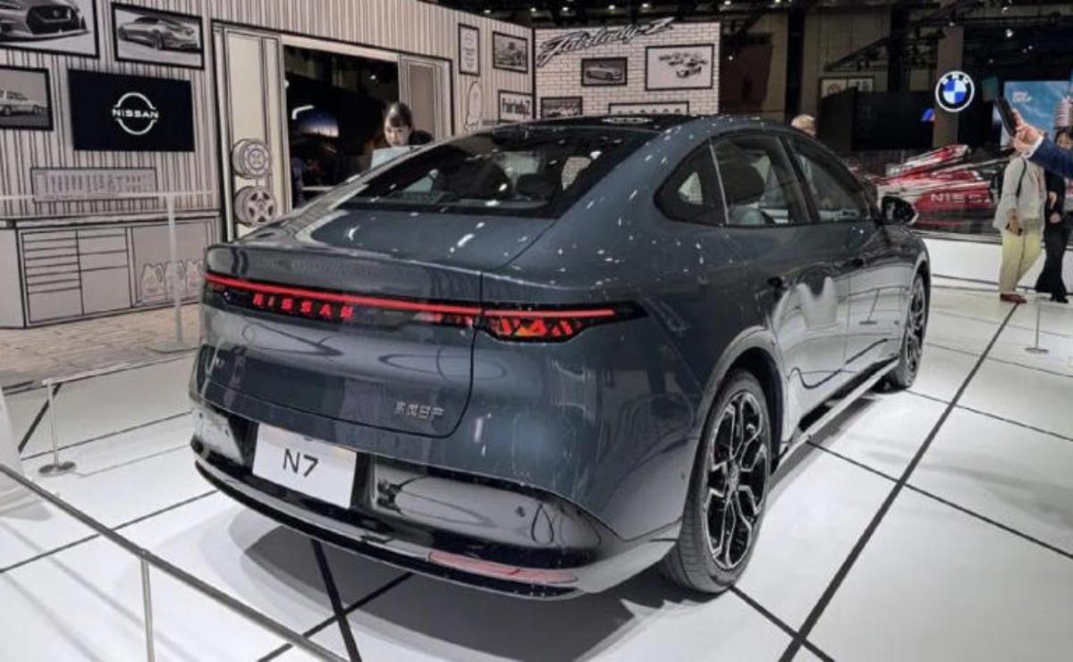 Sleek gray electric sedan displayed at an auto show.