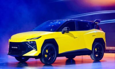 A sleek yellow electric SUV showcased on stage with dynamic lighting.