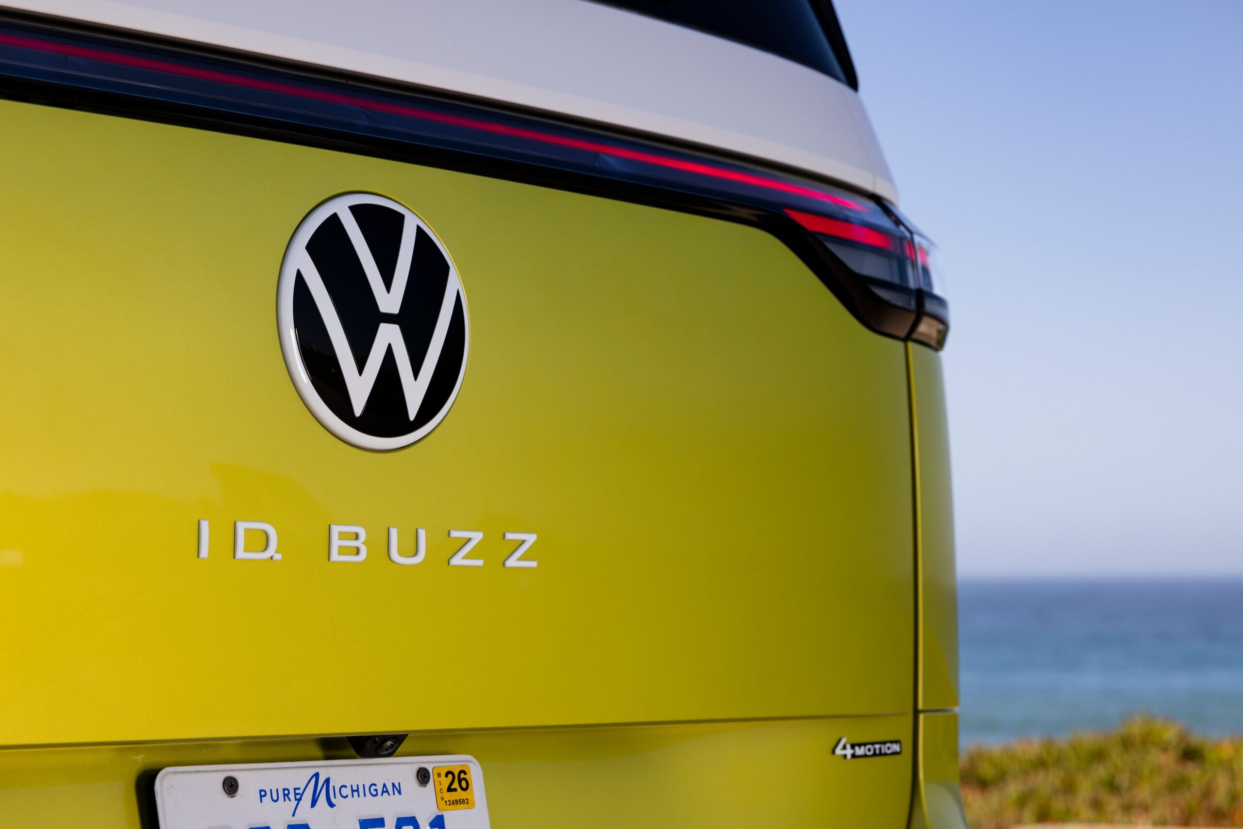 Rear view of a yellow VW ID Buzz electric vehicle with the logo and model name.