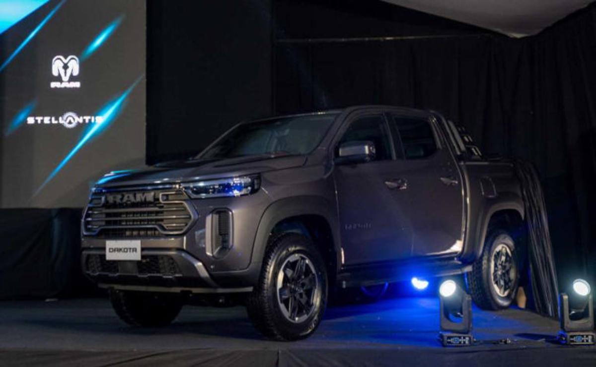 A sleek dark gray pickup truck showcased under dramatic lighting.