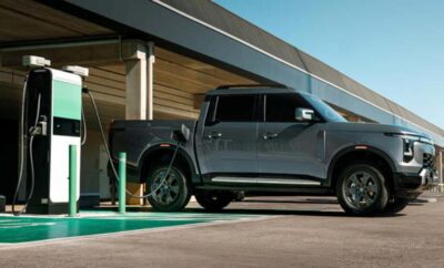 A gray pickup truck parked at an electric vehicle charging station.