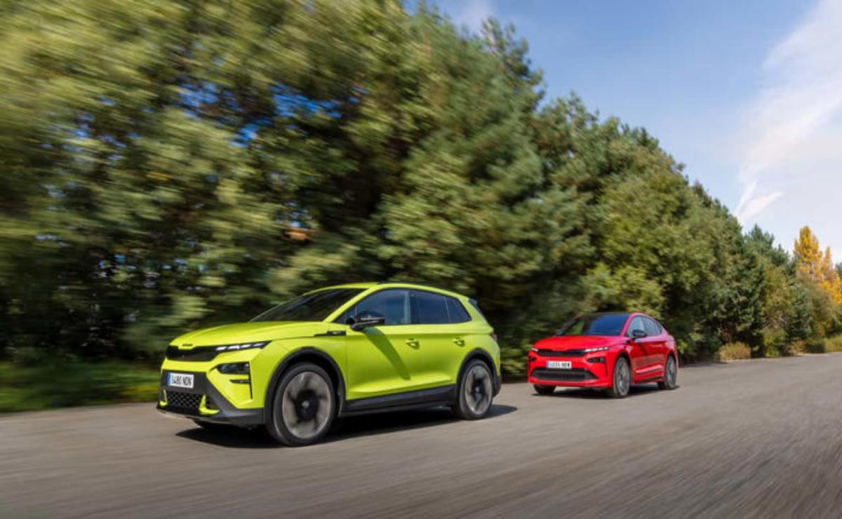 Two sporty cars, one green and one red, driving fast on a road.