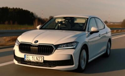 White Skoda sedan driving on a road during sunset.