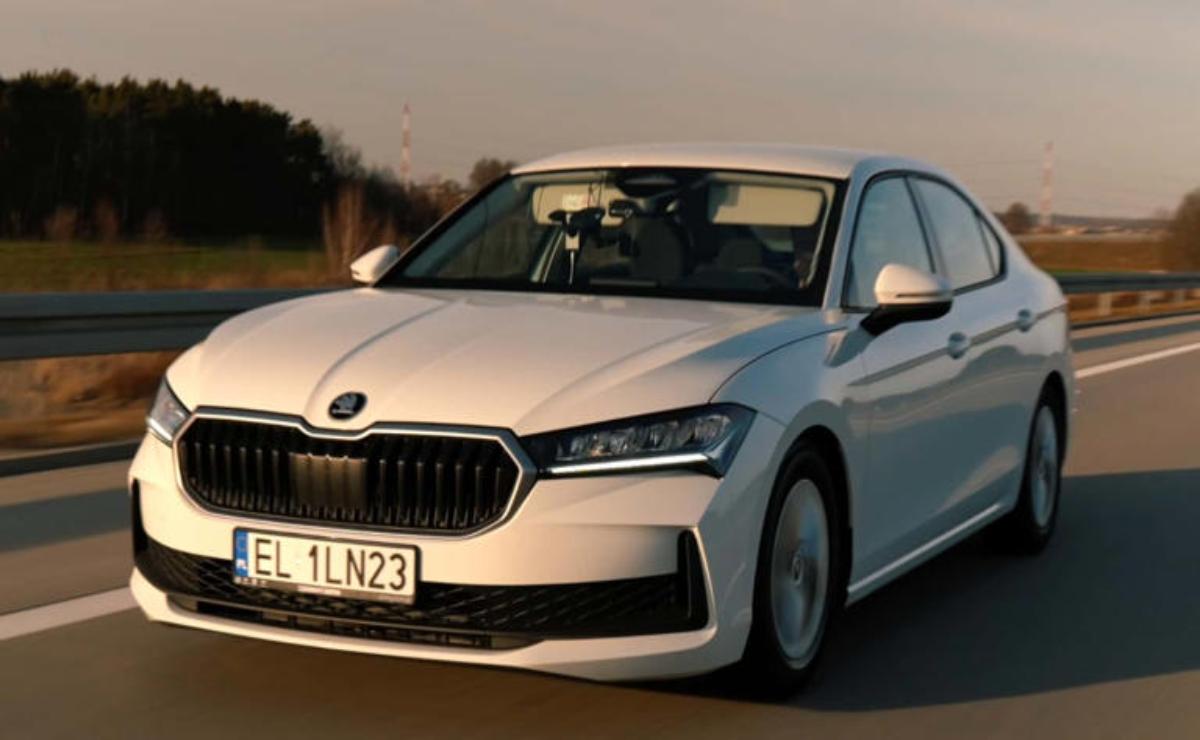 White Skoda sedan driving on a road during sunset.
