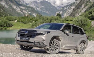 Silver Subaru SUV parked on a gravel road with mountains in the background.