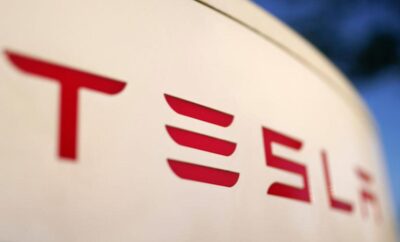 Close-up of Tesla logo on a white surface.
