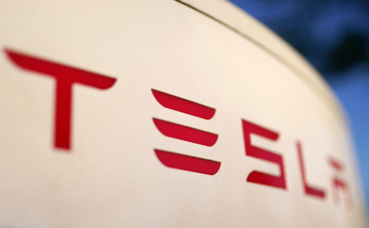 Close-up of Tesla logo on a white surface.