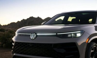 Close-up of a sleek Volkswagen car front with illuminated headlights.