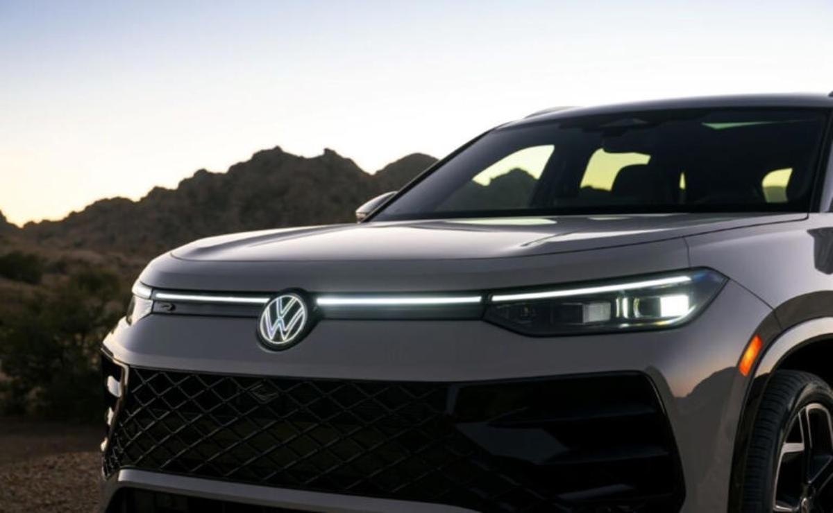 Close-up of a sleek Volkswagen car front with illuminated headlights.