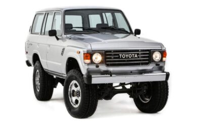 White Toyota SUV with off-road tires and bull bar.