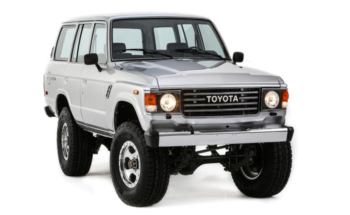 White Toyota SUV with off-road tires and bull bar.