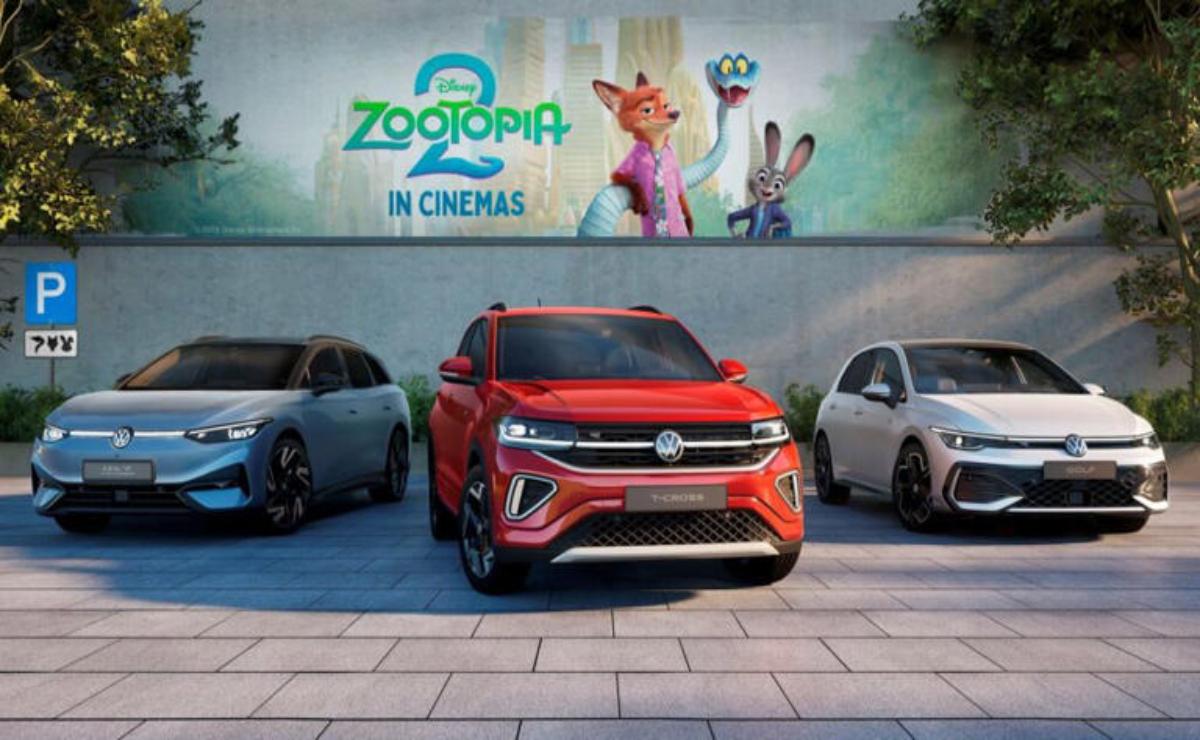 Three Volkswagen cars parked in front of a ZooPia movie billboard.