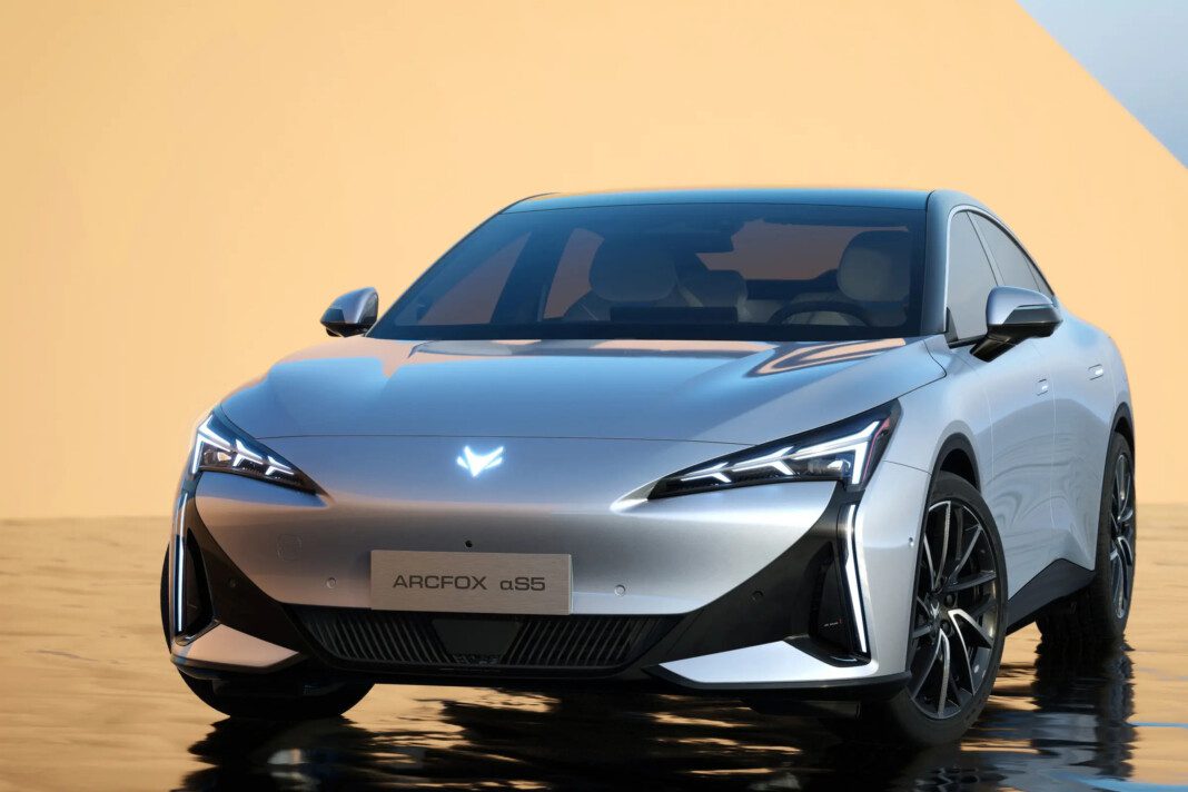 Sleek silver electric car with futuristic design and sharp headlights.