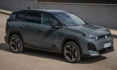 Sleek gray SUV parked beside a wall on a sunny day.