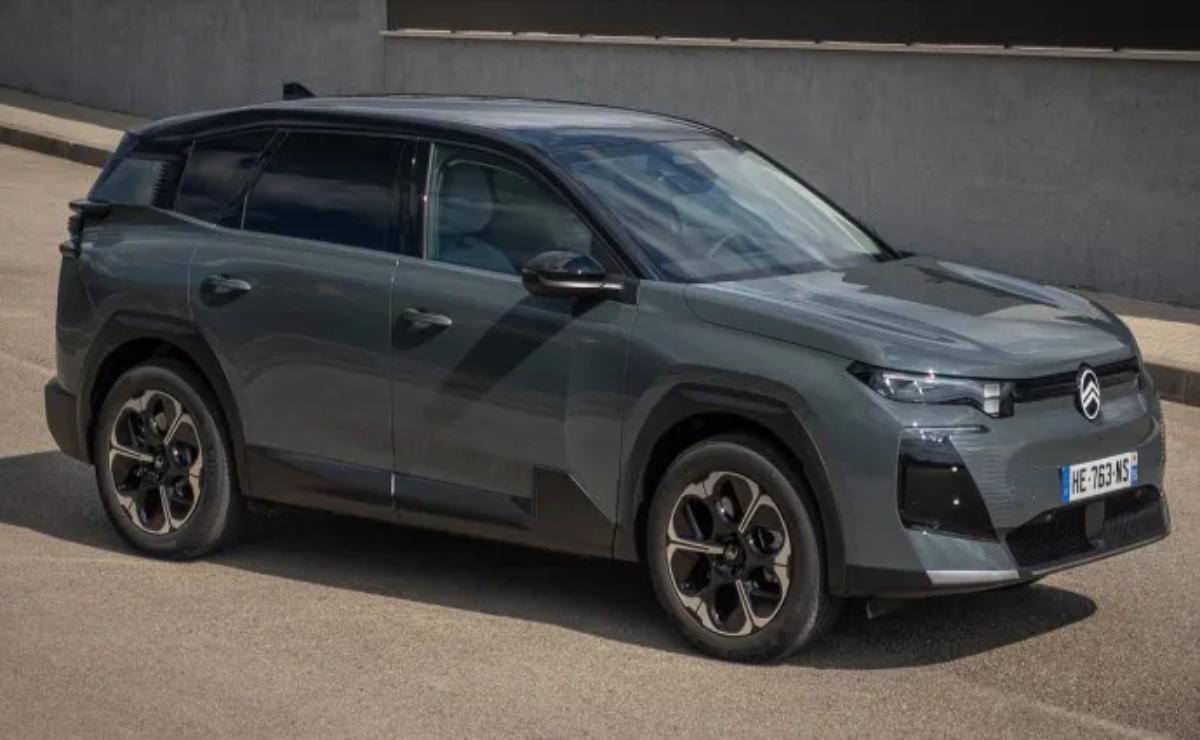 Sleek gray SUV parked beside a wall on a sunny day.