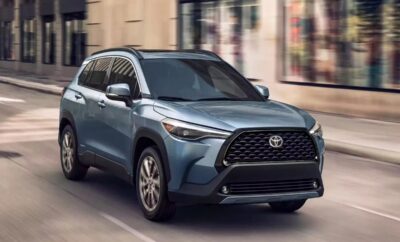 A blue Toyota SUV driving on a city street.