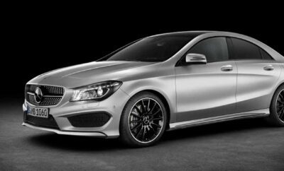 Sleek silver luxury car with black rims on a black background.