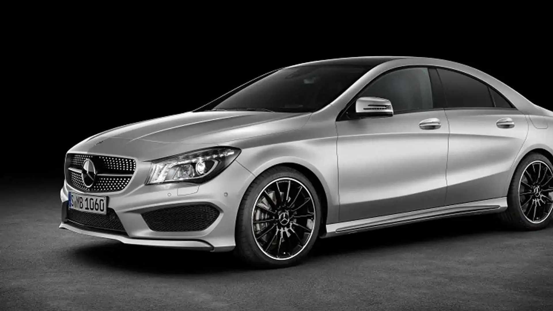 Sleek silver luxury car with black rims on a black background.