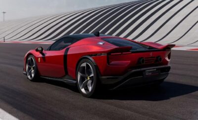 Sleek red sports car parked on a road with a modern architectural background.