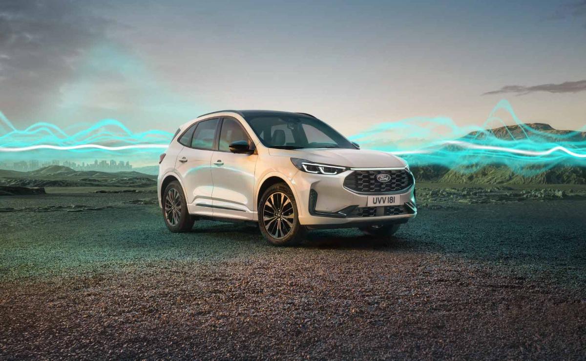 A sleek white electric SUV parked on a gravel surface with a scenic sky backdrop.