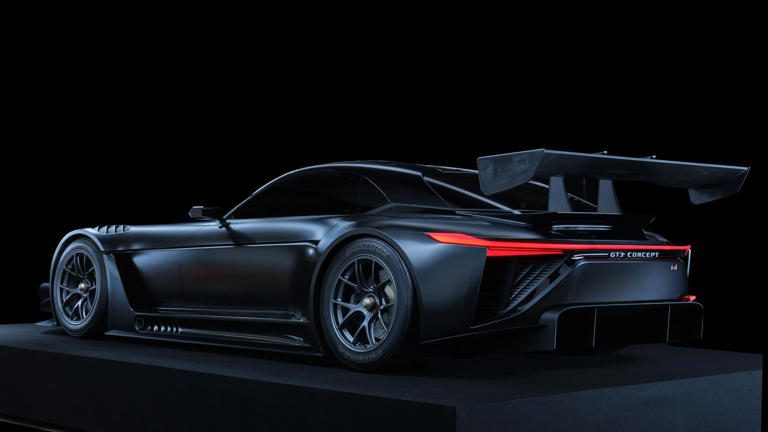 Sleek black sports car with aerodynamic design and illuminated rear lights.