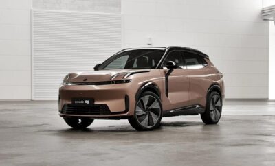 A sleek, modern electric SUV with a bronze finish parked indoors.