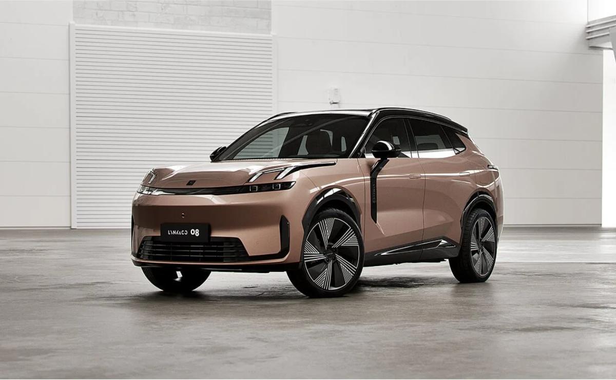 A sleek, modern electric SUV with a bronze finish parked indoors.