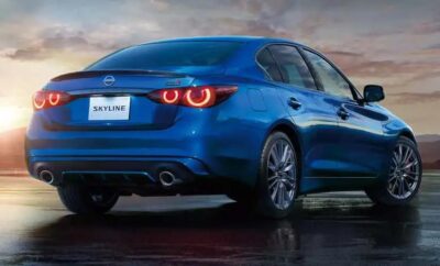 Blue sedan car with glowing red tail lights on a wet road at dusk.