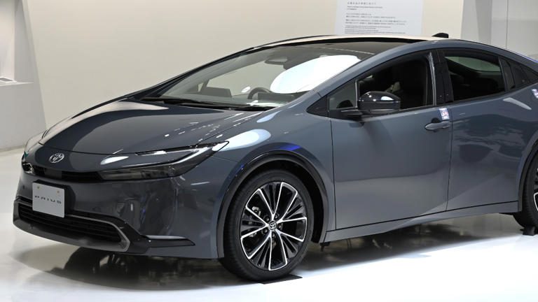 Sleek gray car showcased indoors with modern design and stylish wheels.