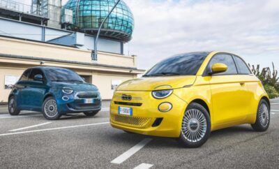 Two compact Fiat cars parked near an observatory under a cloudy sky.