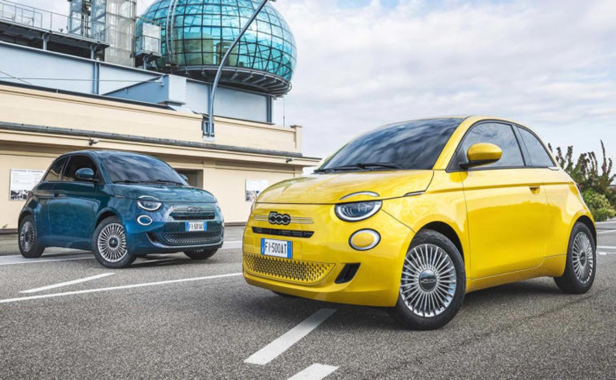Two compact Fiat cars parked near an observatory under a cloudy sky.