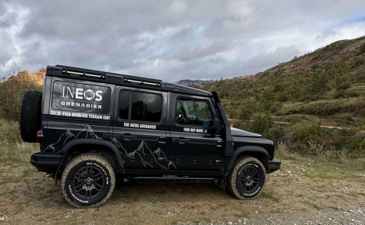 Black off-road vehicle parked on a rugged trail under a cloudy sky.
