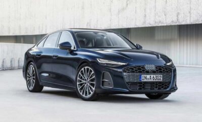 Sleek black luxury sedan parked in front of a modern concrete wall.