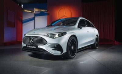 White Mercedes-Benz luxury sedan showcased indoors with dramatic lighting.