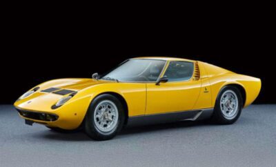 A yellow vintage sports car against a black background.