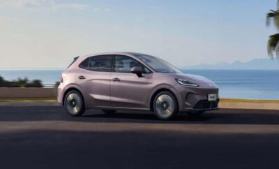 A sleek, modern electric compact car in purple on a road.