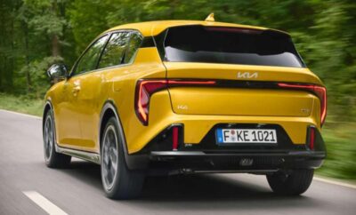 Yellow electric SUV driving on a forest road.