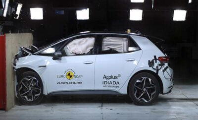 Side view of a crash-tested white car with deployed airbags.