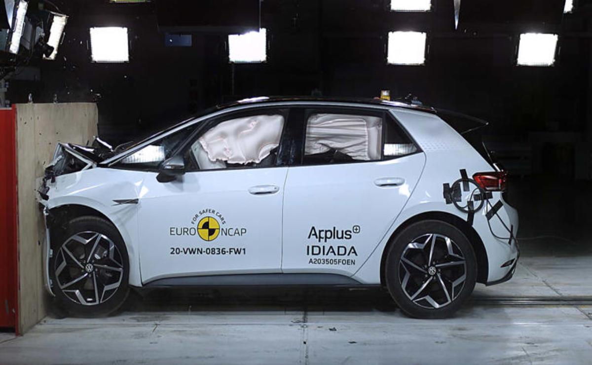 Side view of a crash-tested white car with deployed airbags.